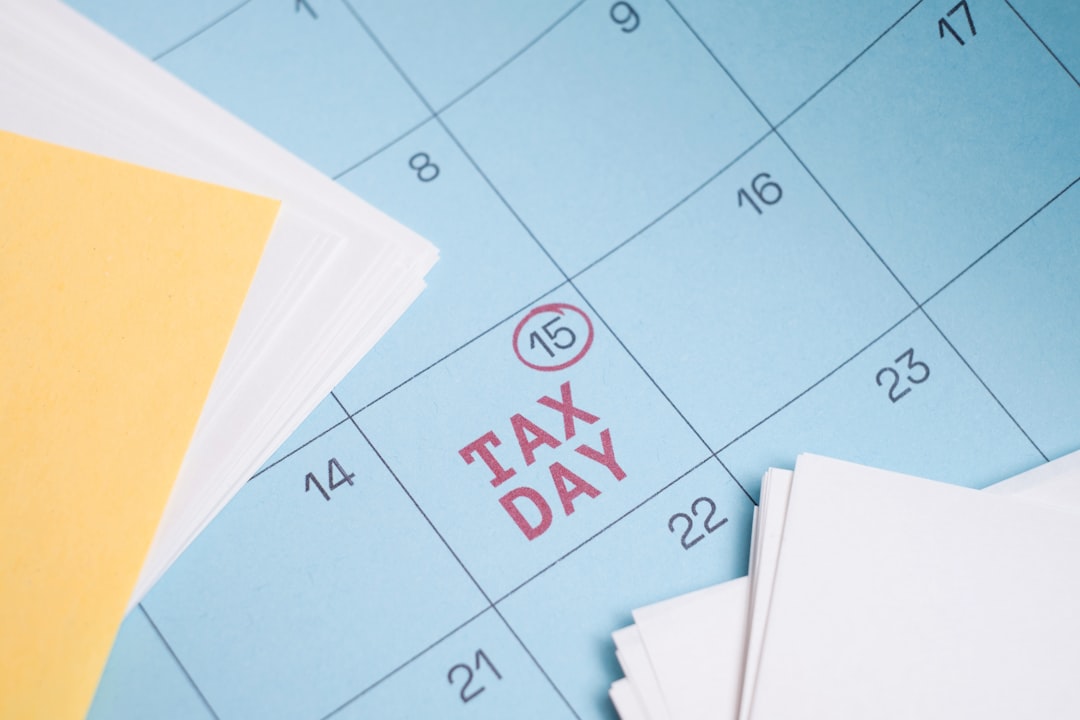 Tax Day. Blue Wall Calendar with April 15 Circled and Labeled as Tax Day Deadline. Close-up